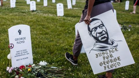 A person holds a sign displaying a portrait of George Floyd during a vigil at an art installation honoring victims of police burtaliuty in Minneapolis in June 2020. (Kerem Yucel/AFP/Getty Images)