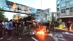 A picture obtained by AFP outside Iran on September 21, 2022, shows Iranian demonstrators burning a rubbish bin in the capital Tehran during a protest for Mahsa Amini, days after she died in police custody. - Protests spread to 15 cities across Iran overnight over the death of the young woman Mahsa Amini after her arrest by the country's morality police, state media reported today.In the fifth night of street rallies, police used tear gas and made arrests to disperse crowds of up to 1,000 people, the official IRNA news agency said. (Photo by AFP) (Photo by -/AFP via Getty Images)