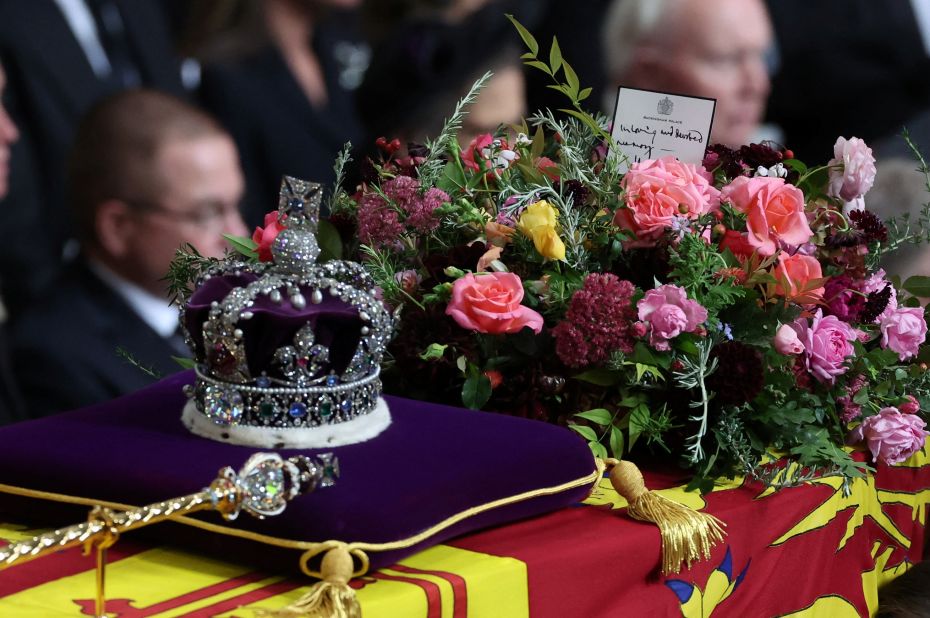 The coffin of Queen Elizabeth II is adorned with the Imperial State Crown during her funeral in London on Monday, September 19. A handwritten card placed on top of the Queen's coffin reads, "In loving and devoted memory. Charles R." The "R" in King Charles' title refers to "Rex," which is Latin for king.