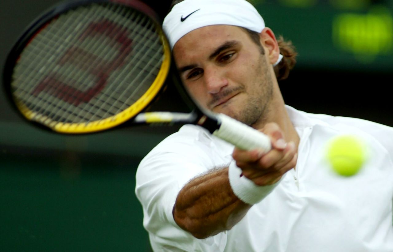 Federer hits a forehand at Wimbledon in 2003. He would go on to win the tournament, his first grand slam title.