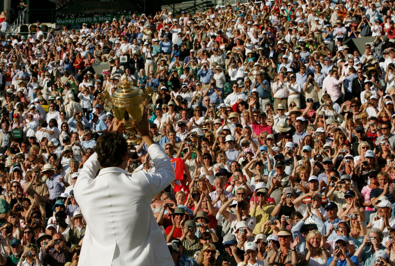 Federer holds up his trophy to the crowd after winning his fifth straight Wimbledon in 2007.
