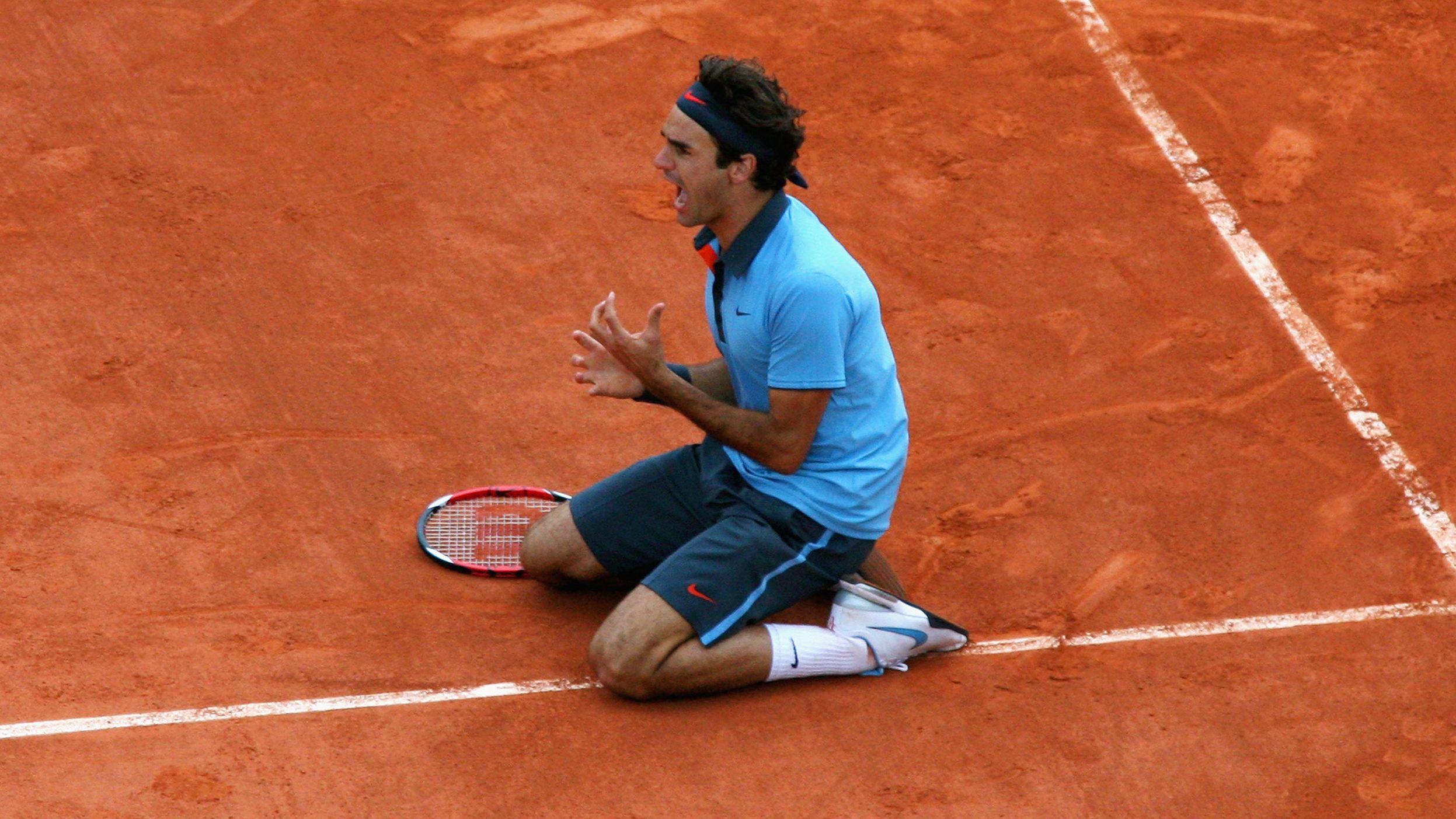 Federer falls to his knees after winning the French Open in 2009. The elusive title completed the career grand slam for Federer.