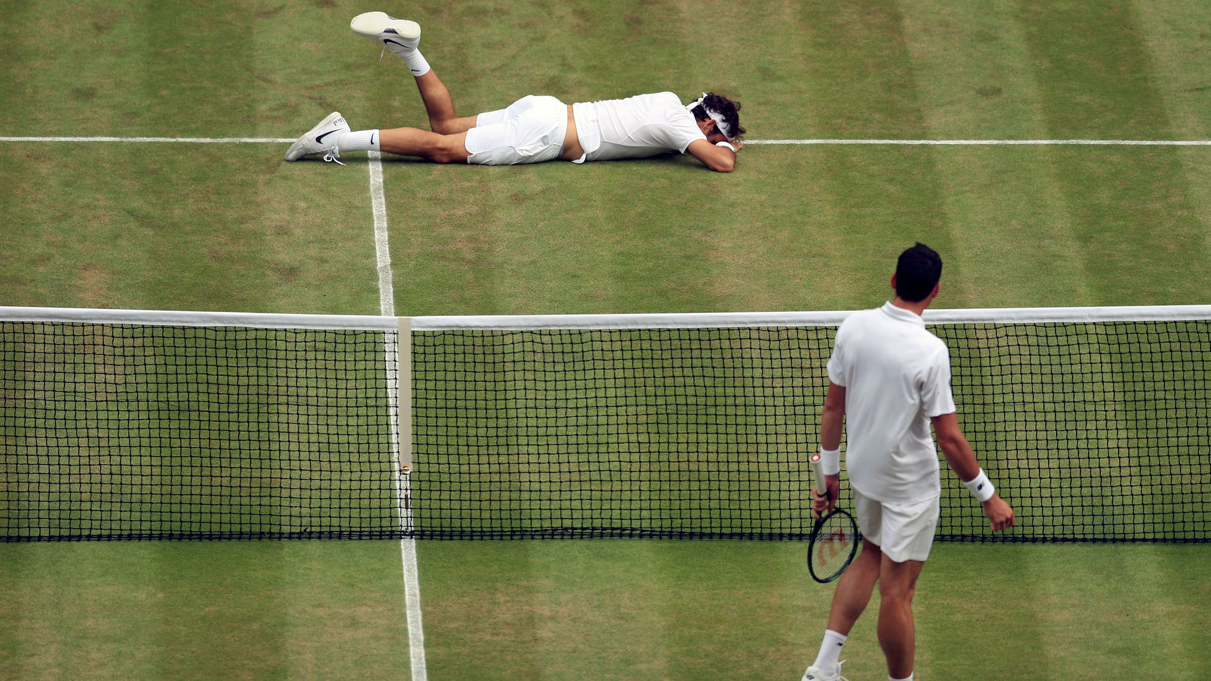 Federer falls over during his Wimbledon semifinal match against Milos Raonic in 2016. He had been struggling with a knee injury that year, and he hurt it again during the loss to Raonic.