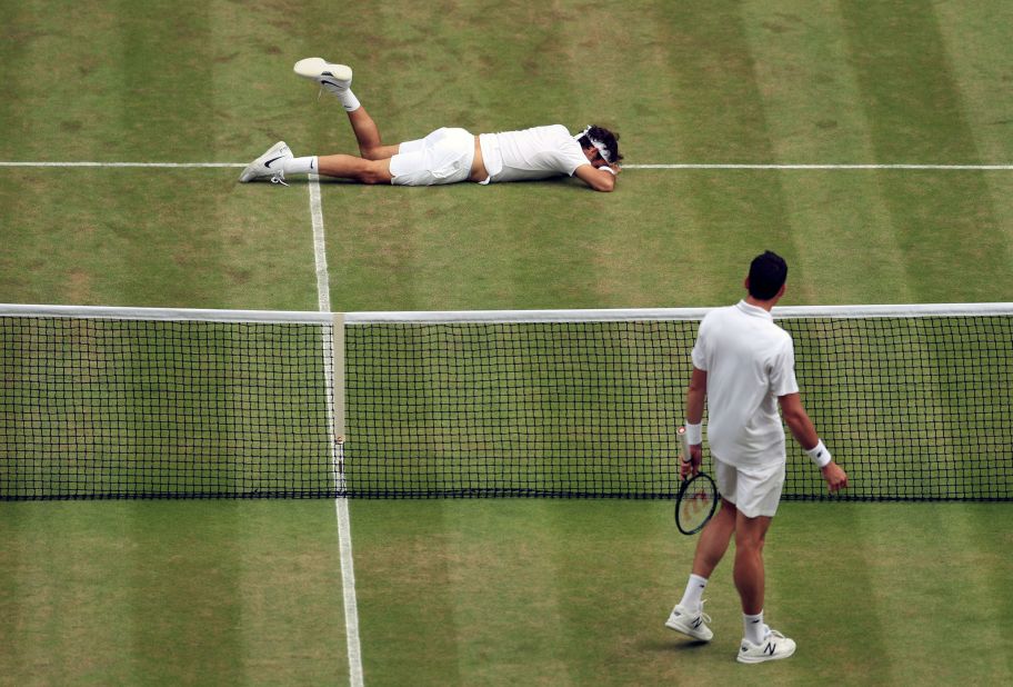 Federer falls over during his Wimbledon semifinal match against Milos Raonic in 2016. He had been struggling with a knee injury that year, and he hurt it again during the loss to Raonic.