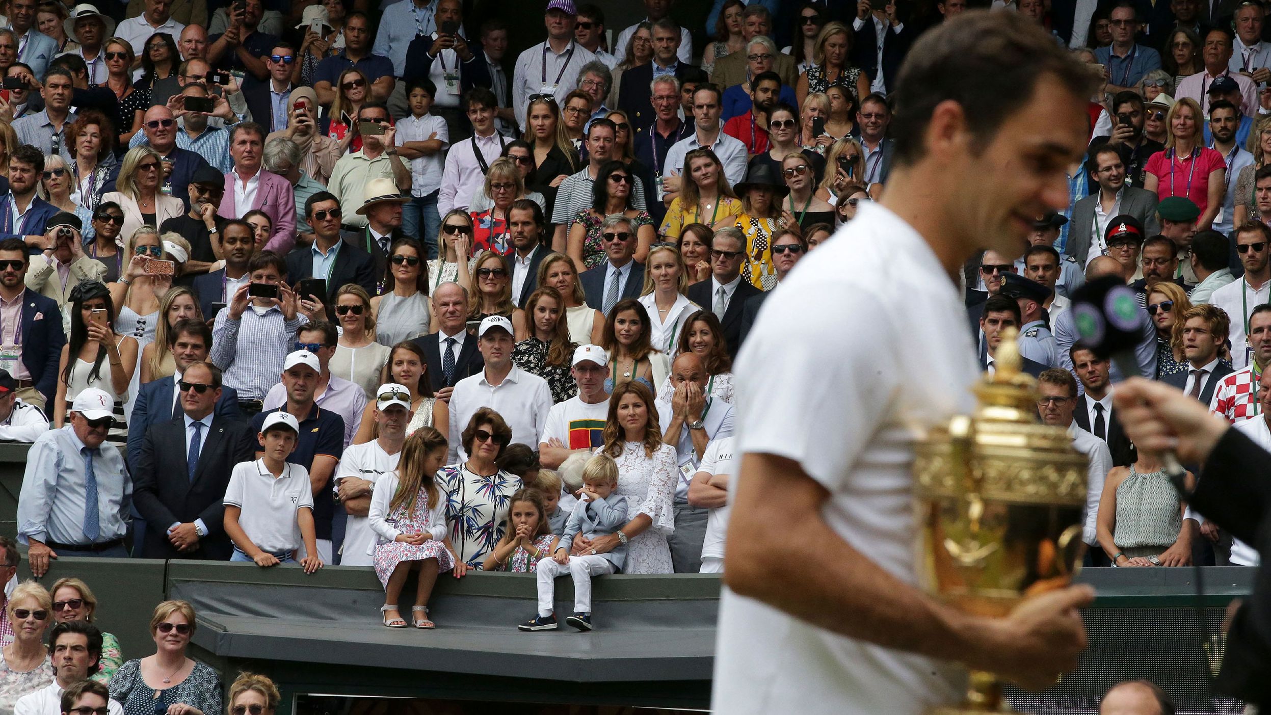 Federer is watched by his wife, Mirka, and their four children after winning Wimbledon in 2017. Federer has two sets of twins: identical twin girls and fraternal twin boys.