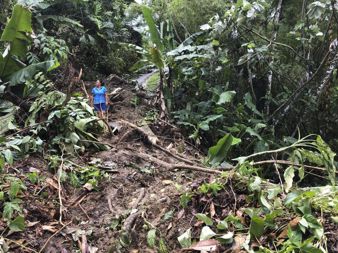 Nancy Galarza looks at the damage Hurricane Fiona inflicted on her community, which remained cut off four days after the storm slammed the rural community of San Salvador in the town of Caguas, Puerto Rico, Thursday.