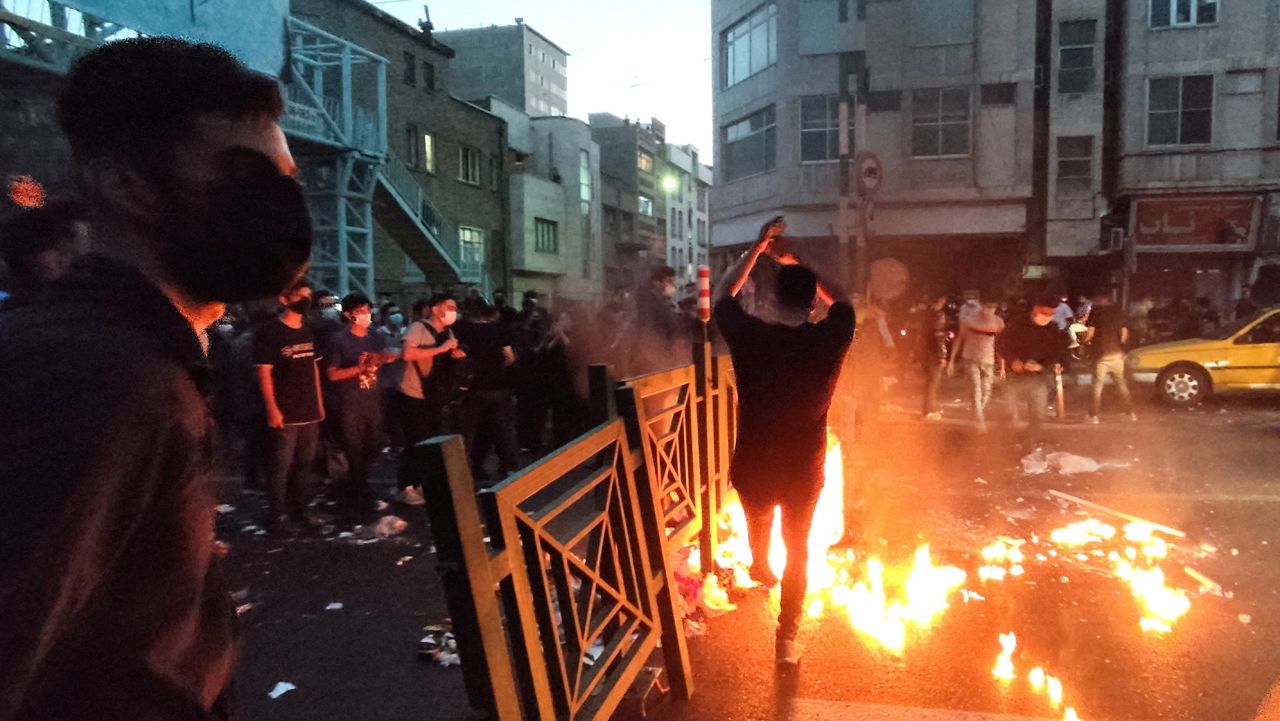 FILE PHOTO: People light a fire during a protest over the death of Mahsa Amini, a woman who died after being arrested by the Islamic republic's "morality police", in Tehran, Iran September 21, 2022. WANA (West Asia News Agency) via REUTERS ATTENTION EDITORS - THIS IMAGE HAS BEEN SUPPLIED BY A THIRD PARTY. BEST QUALITY AVAILABLE DUE TO LIGHTING CONDITIONS/File Photo