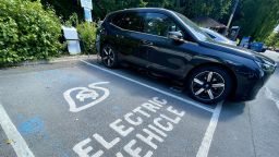 Electric cars are charged by a wall charger in a city centre car park, on July 15, 2022 in Bath, England. 