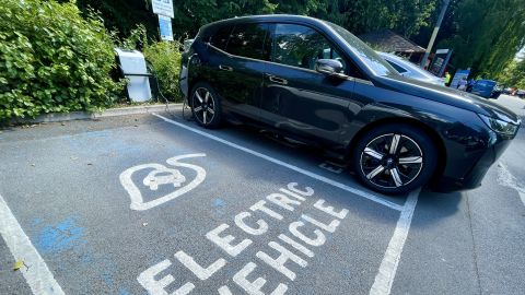 Electric cars are charged by a wall charger in a city centre car park, on July 15, 2022 in Bath, England. 