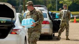 Mississippi National Guardsmen carry cases of drinking water to Jackson, Miss., residents cars, Friday, Sept. 2, 2022, at Smith Wills Stadium. Jackson's water system partially failed following flooding and heavy rainfall that exacerbated longstanding problems in one of two water-treatment plants, and the state is helping with the distribution of drinking water to the city's residents. 