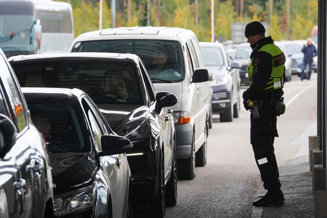 A Finnish border guard officer stands near cars queuing to enter Finland from Russia in Vaalimaa, Finland, on Friday September 23, 2022.
