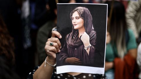 A protester holds a portrait of Mahsa Amini during a demonstration in her support in front of the Iranian embassy in Brussels on September 23, 2022.