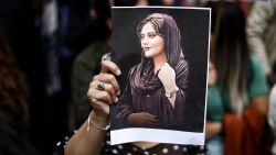 A protester holds a portrait of Mahsa Amini during a demonstration in her support in front of the Iranian embassy in Brussels on September 23, 2022, following the death of an Iranian woman after her arrest by the country's morality police in Tehran. - Mahsa Amini, 22, was on a visit with her family to the Iranian capital Tehran, when she was detained on September 13, 2022, by the police unit responsible for enforcing Iran's strict dress code for women, including the wearing of the headscarf in public. She was declared dead on September 16, 2022 by state television after having spent three days in a coma. (Photo by Kenzo TRIBOUILLARD / AFP) (Photo by KENZO TRIBOUILLARD/AFP via Getty Images)