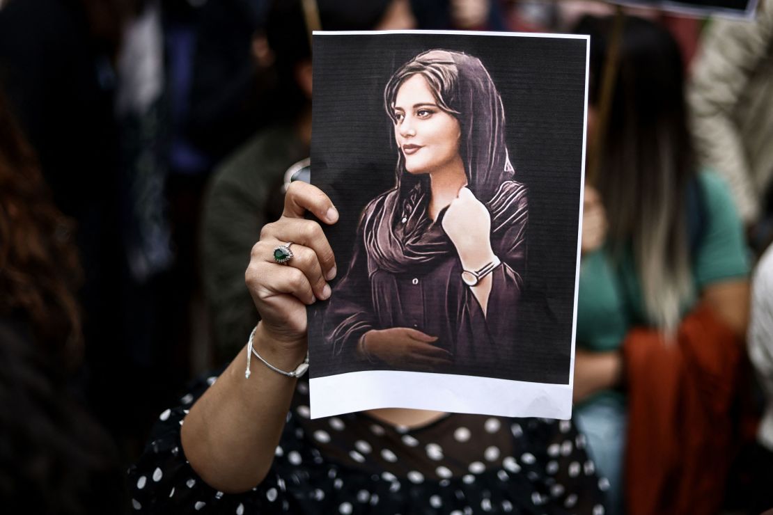 A protester holds a portrait of Mahsa Amini during a demonstration in her support in front of the Iranian embassy in Brussels on September 23, 2022.