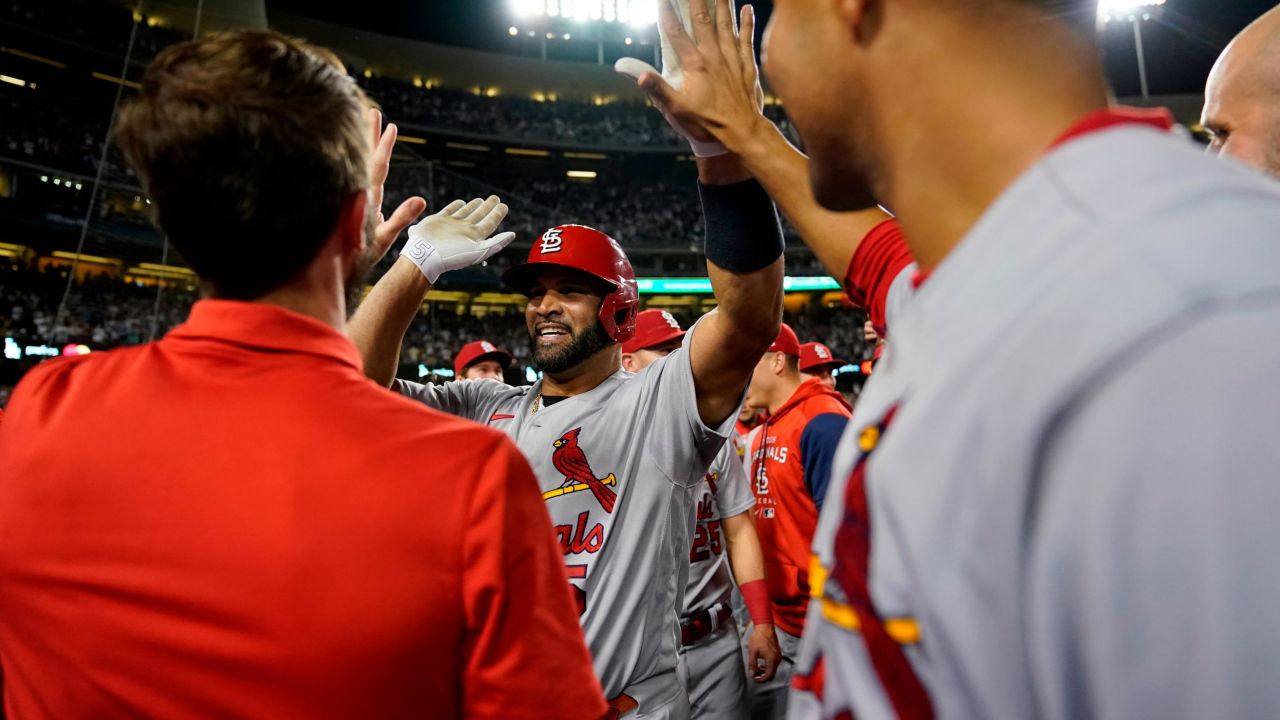 St. Louis Cardinals designated hitter Albert Pujols, center, celebrates with teammates after hitting a home run during the fourth inning of a baseball game against the Los Angeles Dodgers in Los Angeles, Friday, Sept. 23, 2022. It was Pujols' 700th career home run. 