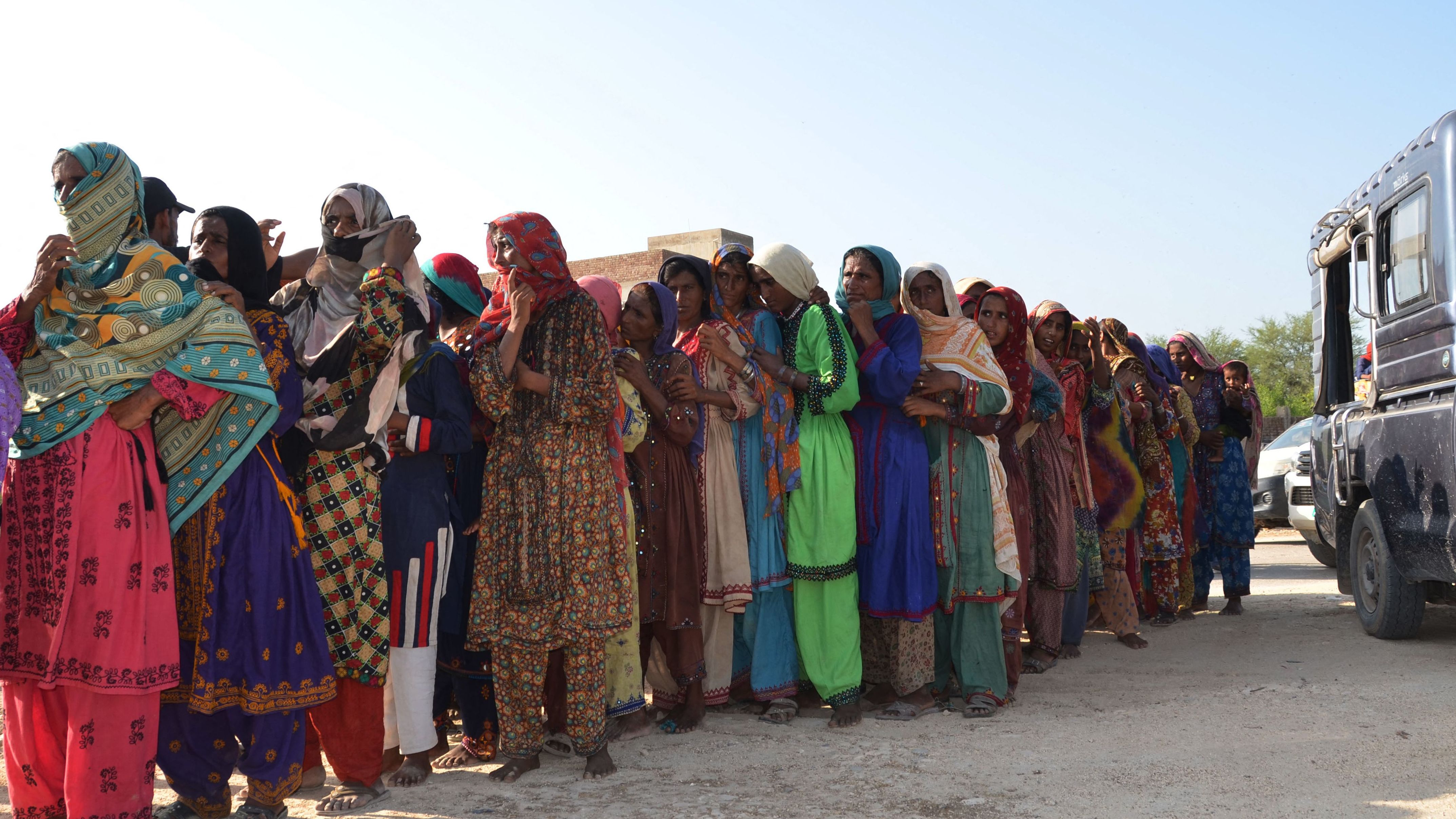 Flood victims line up up to receive food aid at Dera Allah Yar town of Jaffarabad district in Balochistan province on September 17, 2022.