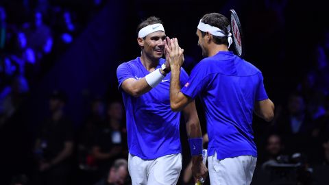 Federer celebrates with Nadal during their doubles match. 