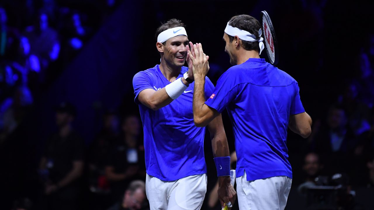 Federer celebrates with Nadal during their doubles match. 