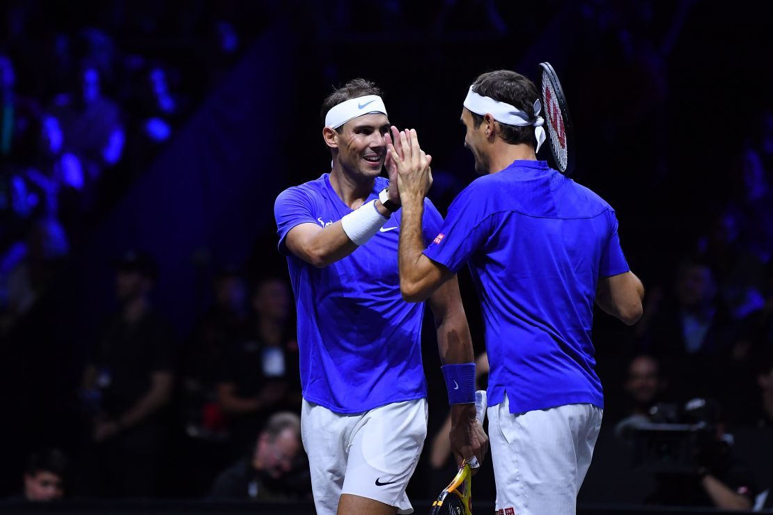 Federer celebrates with Nadal during their doubles match. 