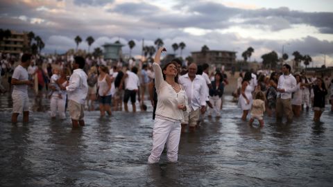 Rabbi Naomi Levy throws bread crumbs into the Pacific Ocean at the Nashuva Spiritual Community Jewish New Year celebration on Venice Beach in Los Angeles on  September 14, 2015.  