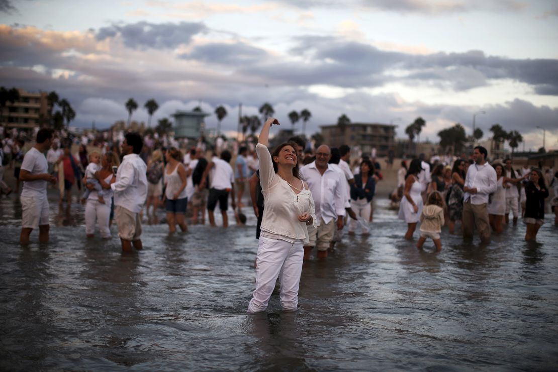 Rabbi Naomi Levy throws bread crumbs into the Pacific Ocean at the Nashuva Spiritual Community Jewish New Year celebration on Venice Beach in Los Angeles on September 14, 2015.