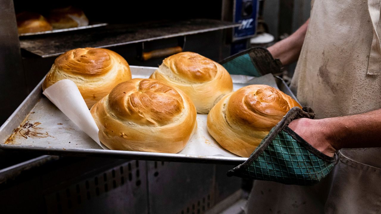 David Rosenberg pulls challah from the oven at Roling's Bakery in Elkins Park, Pennsylvania on September 6, 2021. The bakery sells hundreds of loaves of challah for Rosh Hashanah each year. 