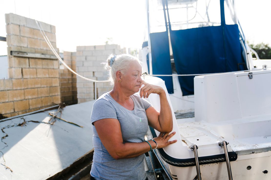 Jacqueline Rivera leans on the boat she and her husband used for shelter during Hurricane Fiona in Salinas, Puerto Rico.