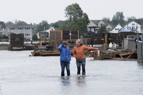 Οι κάτοικοι στέκονται στα νερά της πλημμύρας μετά τον θάνατο της Φιόνα το Σάββατο στο Σέντιακ του Νιού Μπράνσγουικ.