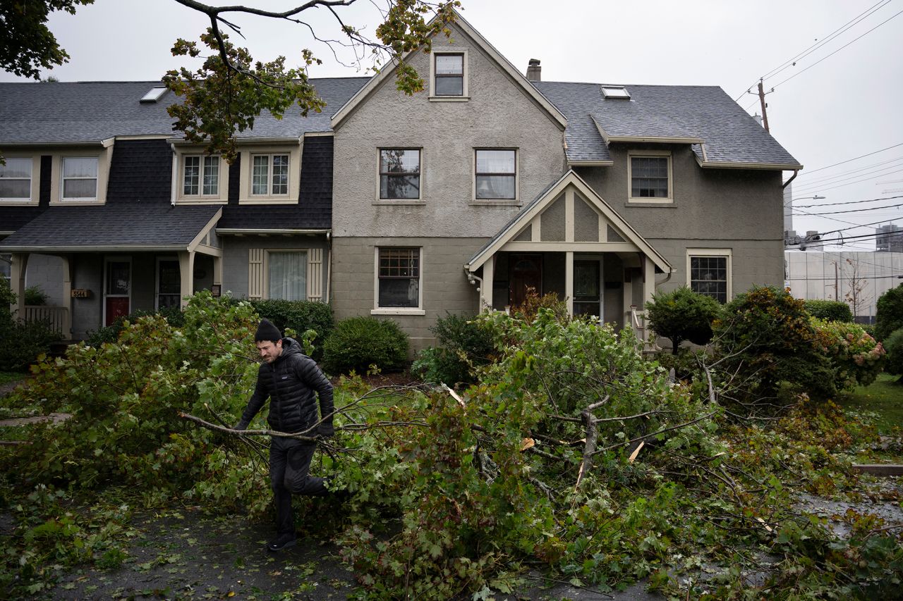 A man clears limbs and debris from his street in Halifax on Saturday.