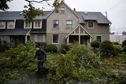 A man removes limbs and debris from his street in Halifax on Saturday.