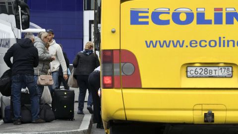 Des passagers descendent d'un autocar en provenance de Saint-Pétersbourg, en Russie, après son arrivée à l'aéroport d'Helsinki à Vantaa, en Finlande, le 24 septembre 2022.