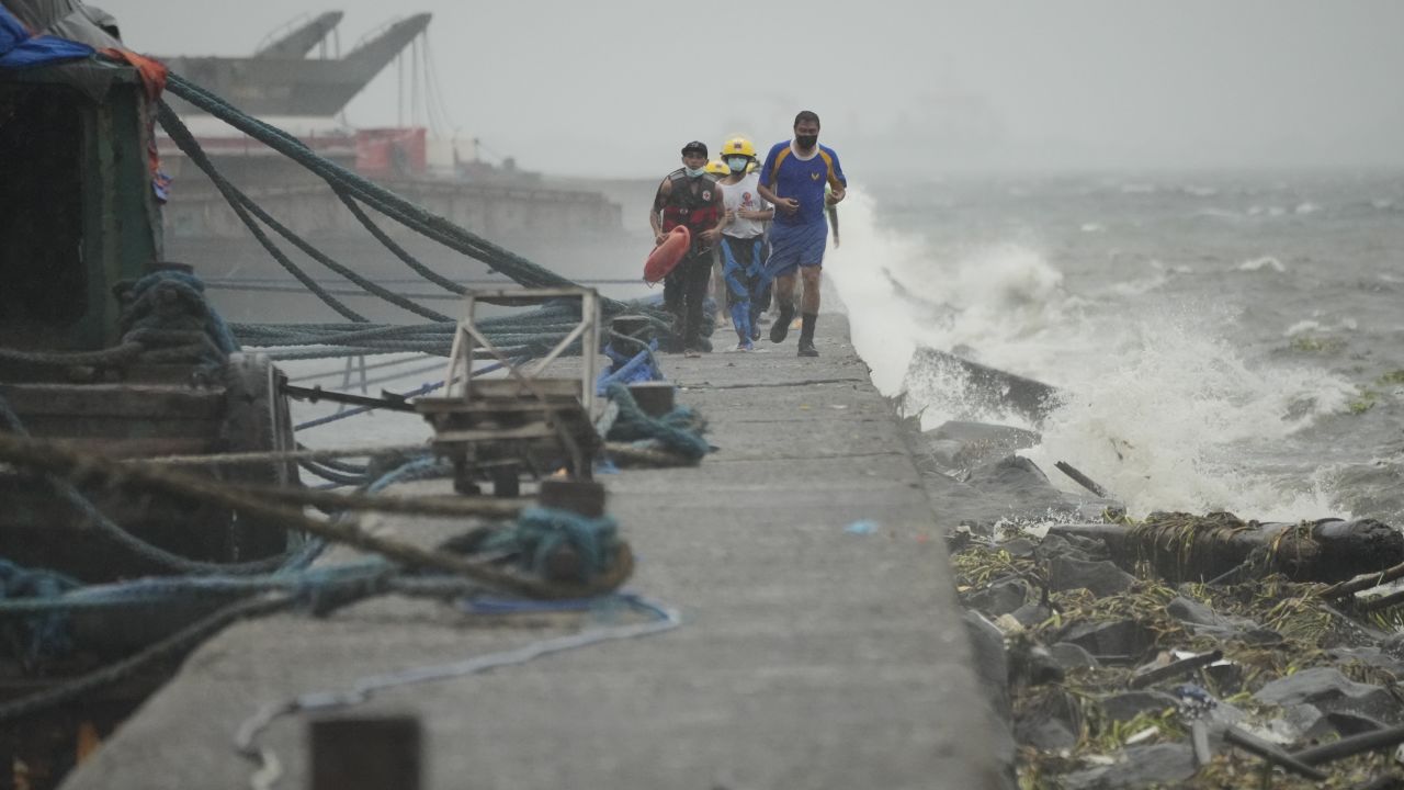 Rescuers run as they check residents living in the seaside slum district of Tondo as Typhoon Noru approaches Manila, in the Philippines, on Sunday.