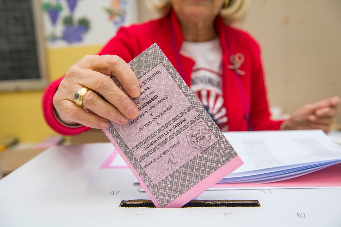 A woman places her ballot paper in the ballot box as Italians vote to elect a new parliament on September 25, 2022 in Bologna, Italy.