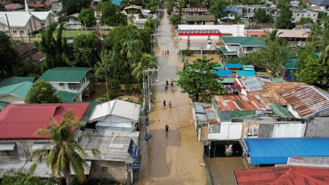 2022 年 9 月 26 日、フィリピンのブラカン州サンミゲルで、スーパー台風 Noru の後、腰までの深さの洪水の中を歩く住民。