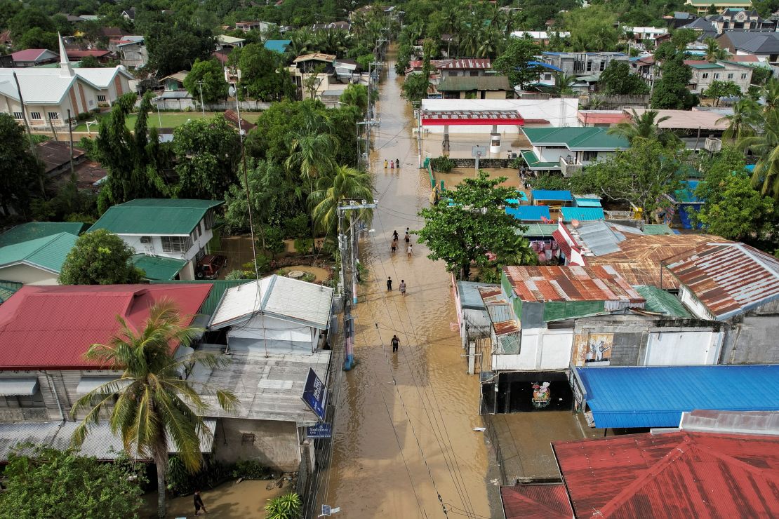 Residents wade through submerged streets after Typhoon Noru in San Miguel, Bulacan province, Philippines, on September 26.