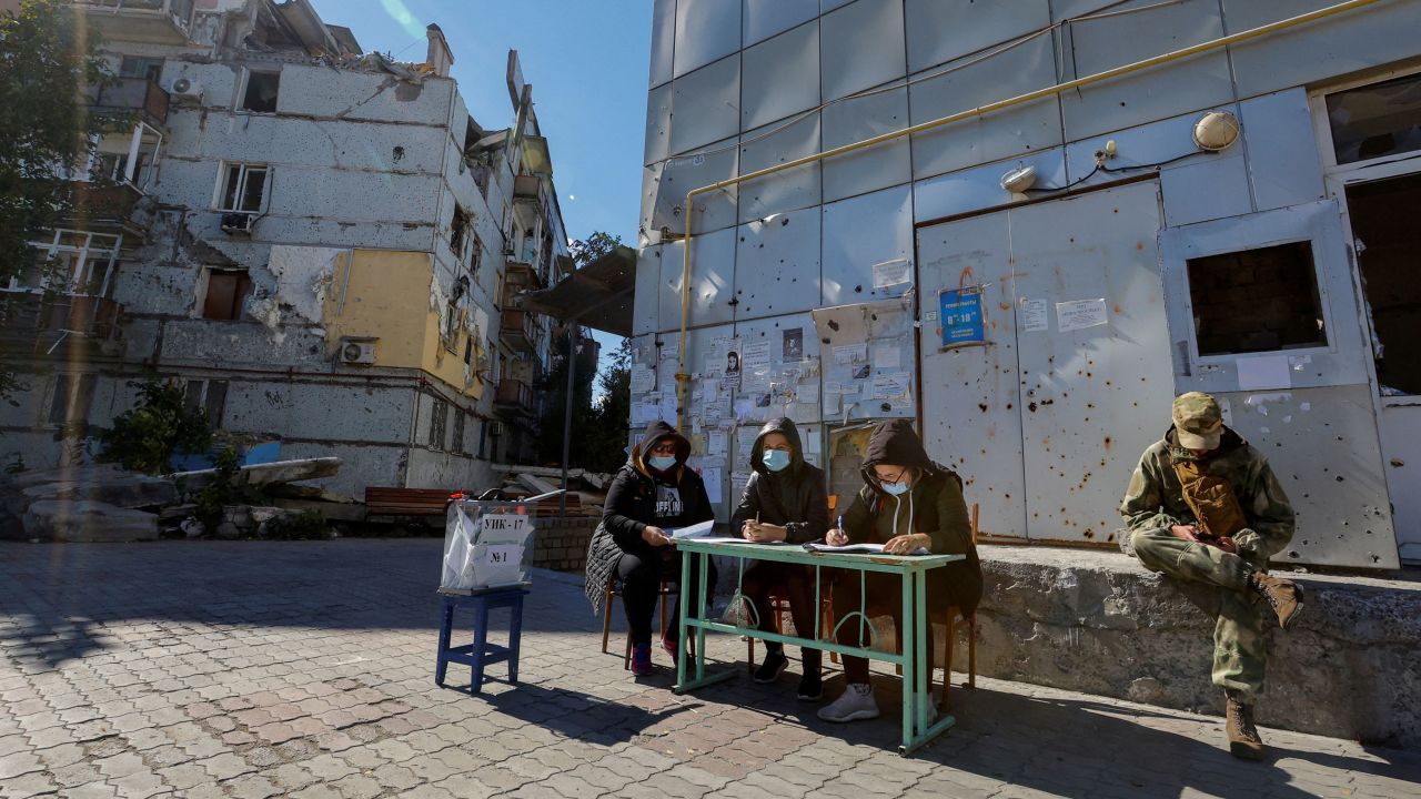 Members of an electoral commission wait for voters near a destroyed residential building on the third day of a referendum on the joining of the self-proclaimed Donetsk People's Republic (DPR) to Russia, in Mariupol, Ukraine September 25, 2022. REUTERS/Alexander Ermochenko