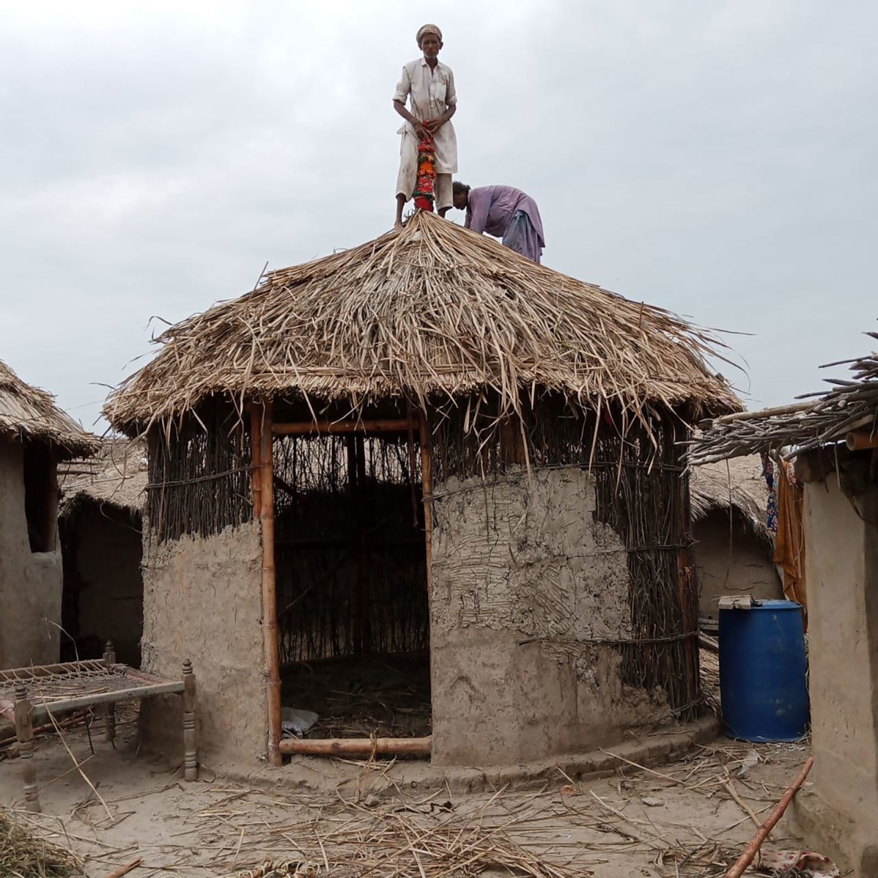 Villagers use materials like mud to fortify the walls of the bamboo shelter.