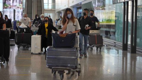 Pazartesi günü Hong Kong Uluslararası Havalimanı'na gelen yolcular.