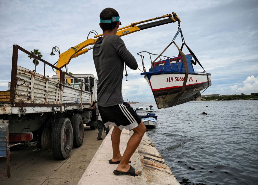 A man helps pull small boats out of Cuba's Havana Bay on Monday.