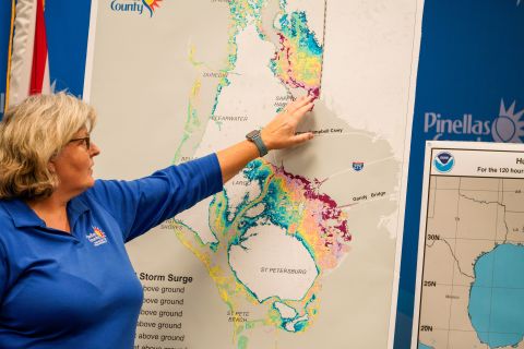 Cathie Perkins, emergency management director in Pinellas County, Florida, references a map that indicates where storm surges would impact the county. During a news conference, she urged anyone living in those areas to evacuate.
