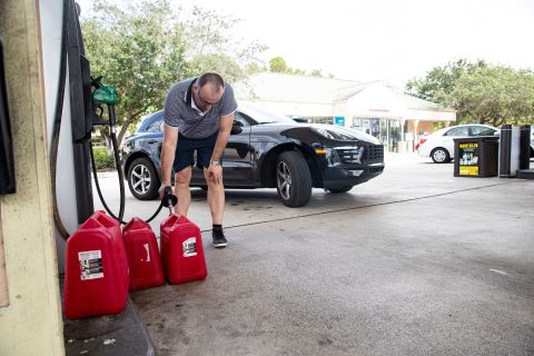Besnik Bushati riempie i contenitori di gas in una stazione di servizio a Naples, in Florida, sabato.  Quella mattina la stazione aveva solo benzina premium.