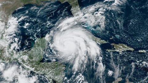 A satellite image from the National Oceanic and Atmospheric Administration shows Hurricane Ian near Cuba, right, on Monday at 1:00 p.m. ET.