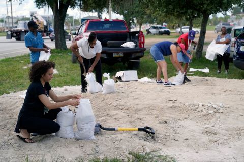 La gente a Orlando ha riempito i sacchi di sabbia lunedì per aiutare a proteggere le loro case dalle inondazioni.