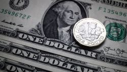 A £1 pound coin is seen alongside US dollar bills on April 4, 2017 in Bath, England.