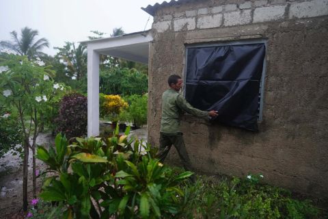 Farmer Cito Braga puts plastic on a window of his home ahead of the arrival of Hurricane Ian in Coloma, Cuba, Monday, September 26.