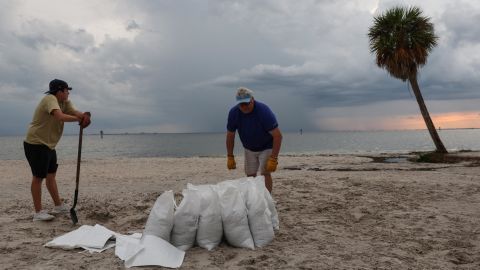 Rich Reynolds e suo figlio John, 18 anni, riempiono sacchi di sabbia a Ben T. Davis Beach a Tampa, in Florida, lunedì.