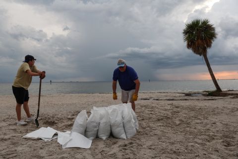 Rich Reynolds e suo figlio John riempiono sacchi di sabbia a Ben T. Davis Beach a Tampa, in Florida.