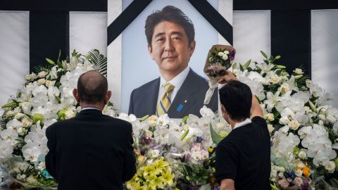 People leave flowers and pay their respects to former Japanese Prime Minister Shinzo Abe outside the Nippon Budokan in Tokyo on September 27.