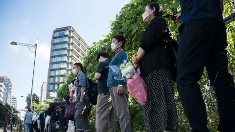 People wait in line to offer flowers at a park near the venue for the state funeral of Shinzo Abe in Tokyo, Japan, on September 27.