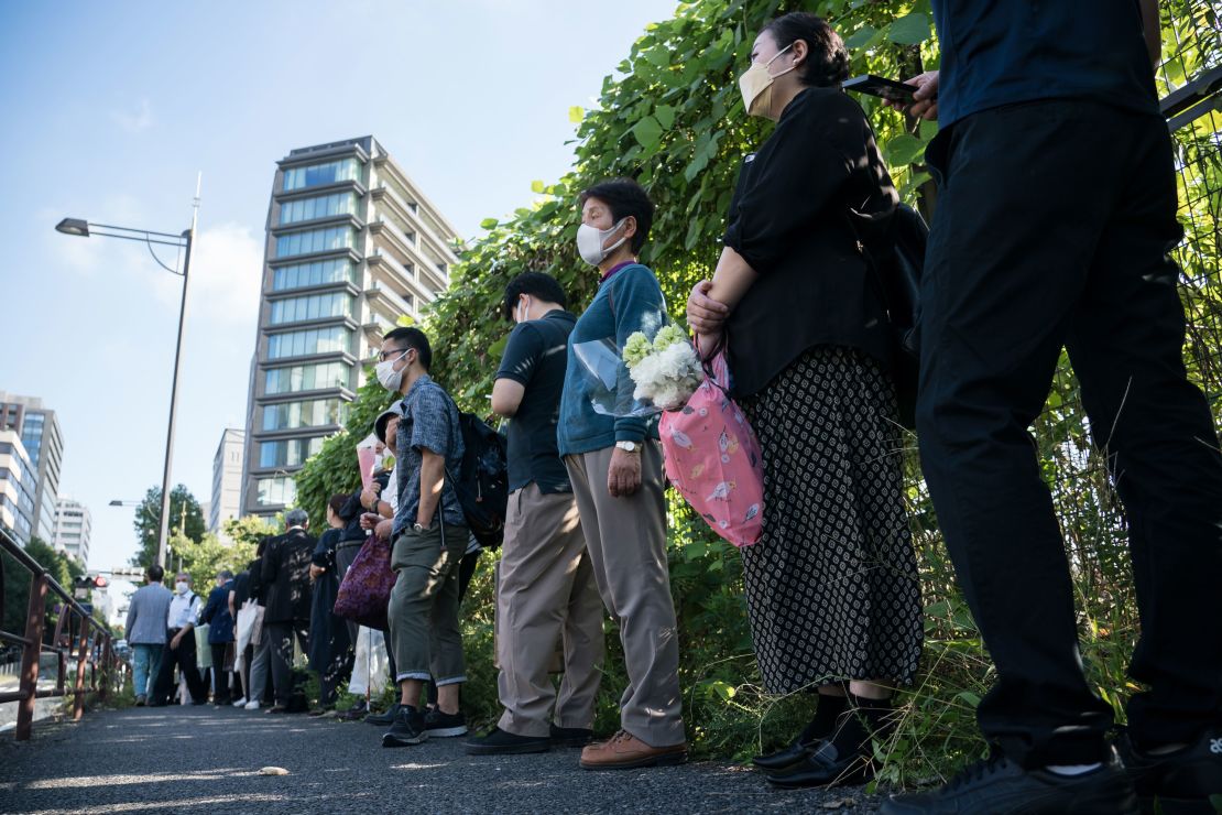 People wait in line to offer flowers at a park near the venue for the state funeral of Shinzo Abe in Tokyo, Japan, on September 27.